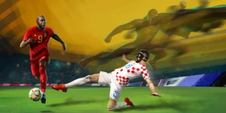 Hrvatski nogometaš u kockastom dresu u klizećem startu oduzima loptu protivniku